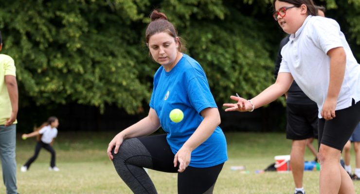 PE teacher watching over student throwing ball