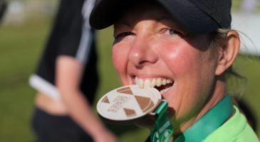 Woman biting her medal
