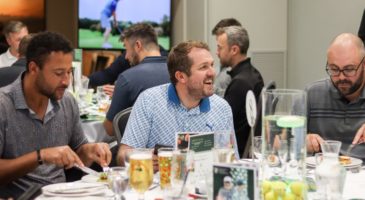 A man sat smiling at dinner