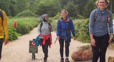 two women walking on a beach path