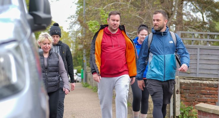 group of people walking along a pavement