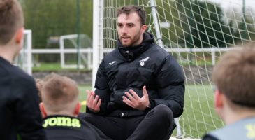 A coach in Norwich City kit takes a session