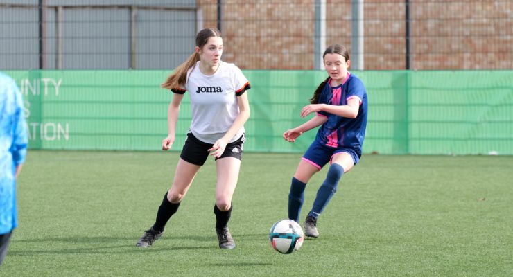 Two young people playing football