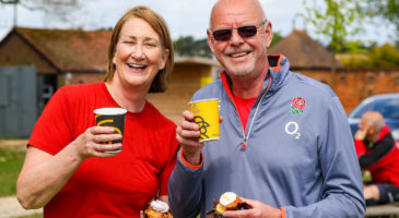 Two people smiling with cups of coffee