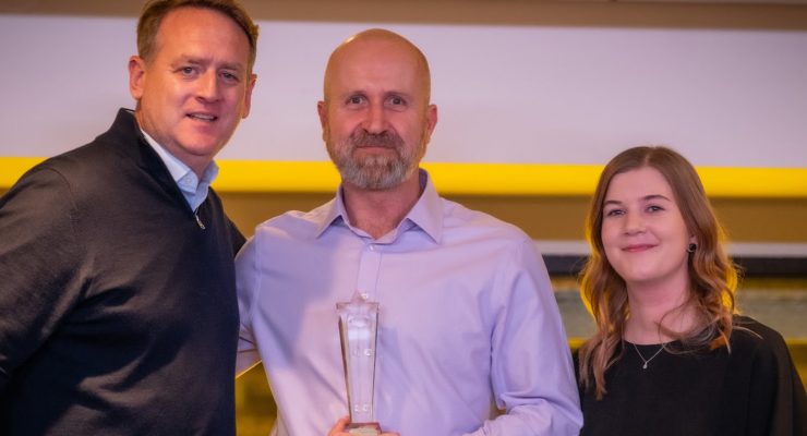 Three people with trophy