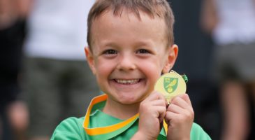 Child posing with a medal