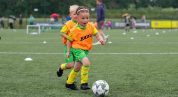 Child in Joma bib playing football