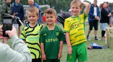 Children in Norwich and Arsenal shirts posing for a photo