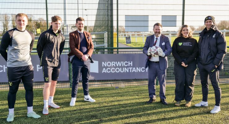 six people standing around the norwich accountancy pitch board