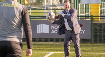 a man in a suit throwing a football