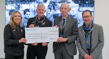 three men and woman with cheque